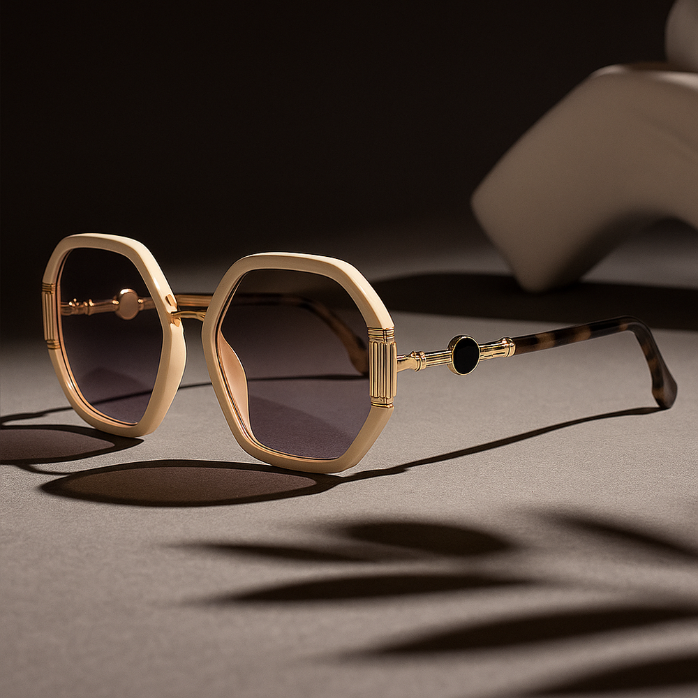 Gold-framed sunglasses with dark lenses on a textured surface