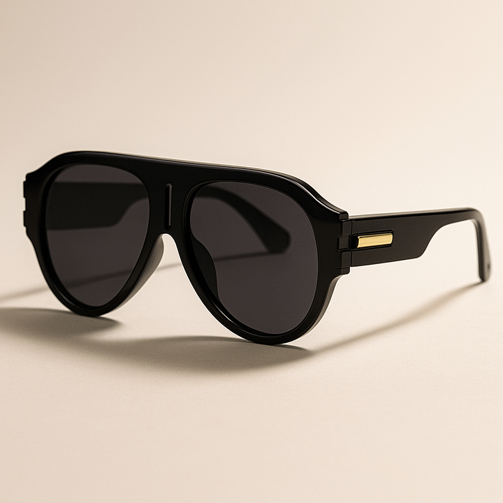 Black sunglasses with gold accents on a beige background
