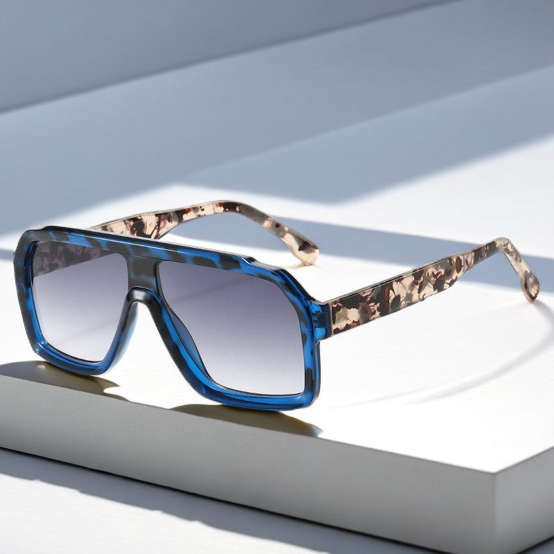 Sunglasses with blue lenses and camouflage arms on a light background