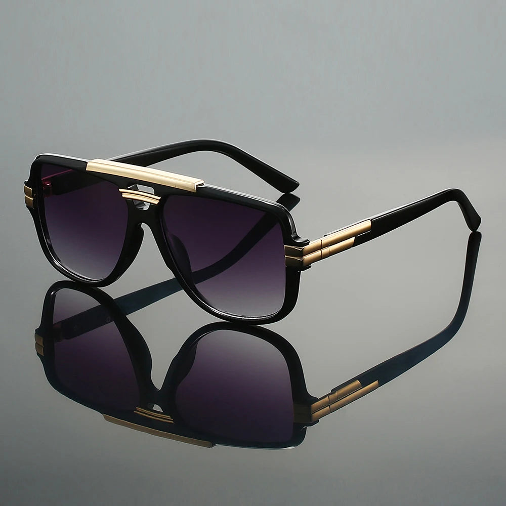 Sunglasses with black and gold frame on a reflective gray surface