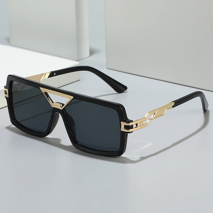 Sunglasses with black frames and gold accents on a light gray background